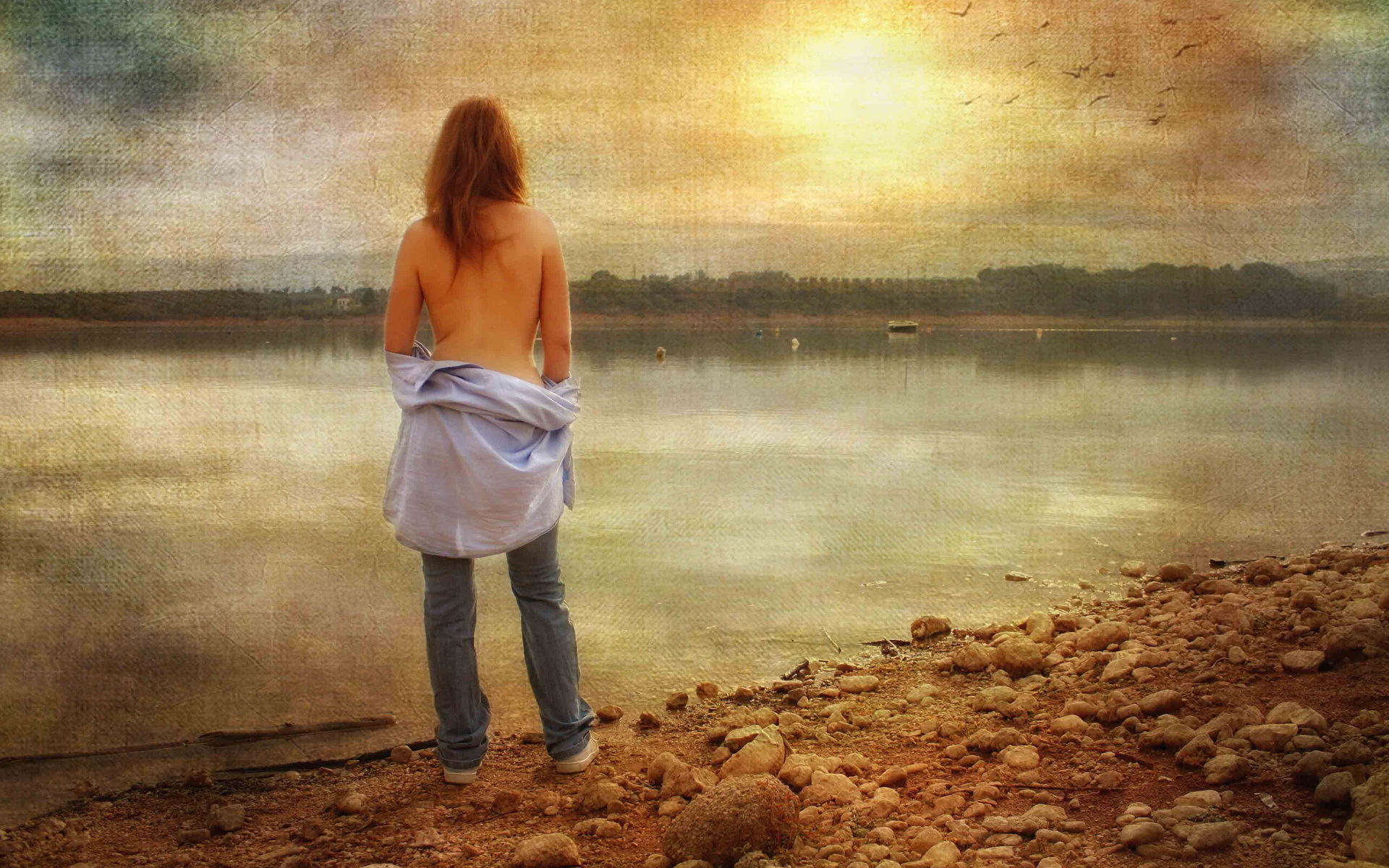 Привлекательная дама позирует голой на берегу реки