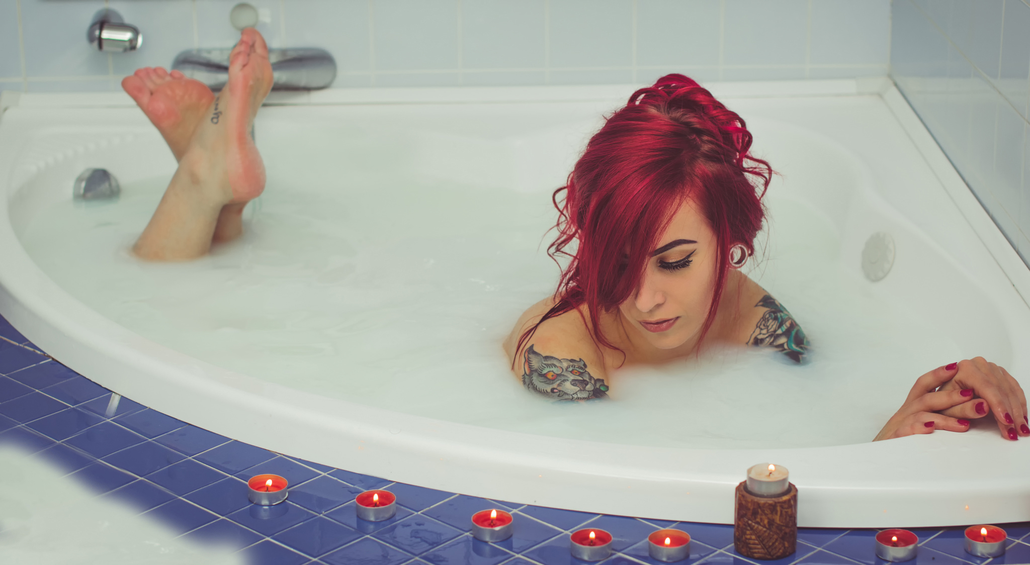 Рыжеволосая женщина шалит в ванне