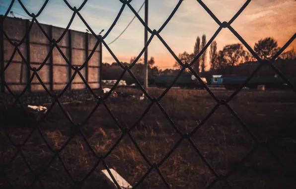 Picture sadness, the sun, sunset, yellow, the city, garbage, mesh, dark, the fence, dark